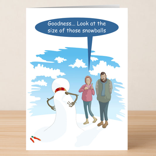 The Snow Balls Funny Christmas Card by Twisted Gifts features a snowman with two big lumps on its chest, surprising a woman who says, "Goodness... Look at the size of those snowballs," while two carrots lie on the ground for a festive touch.