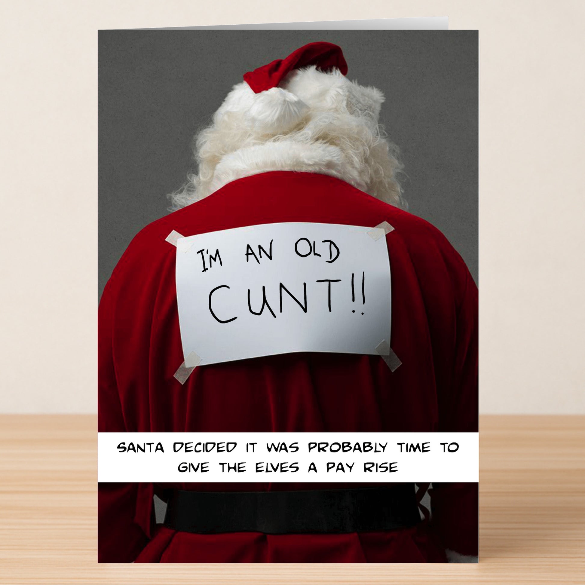 The Pay Rise Rude Christmas Card by Twisted Gifts features Santa with a handwritten sign on his back, joking, "Santa decided it was probably time to give the elves a pay rise." Perfect for anyone who appreciates a humorous Christmas twist!.