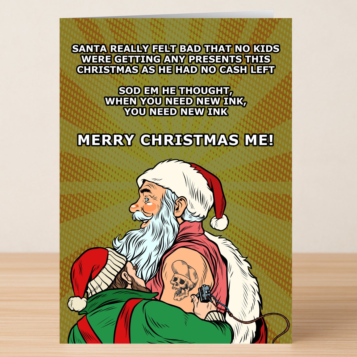 The New Ink Funny Christmas Card by Twisted Gifts is a hilarious holiday greeting featuring Santa getting a skull tattoo because he’s out of cash for presents—so he wishes himself a Merry Christmas instead.