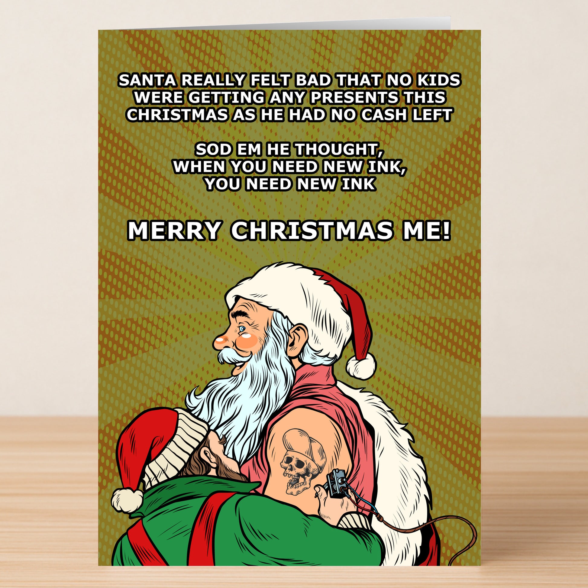 The New Ink Funny Christmas Card by Twisted Gifts is a hilarious holiday greeting featuring Santa getting a skull tattoo because he’s out of cash for presents—so he wishes himself a Merry Christmas instead.