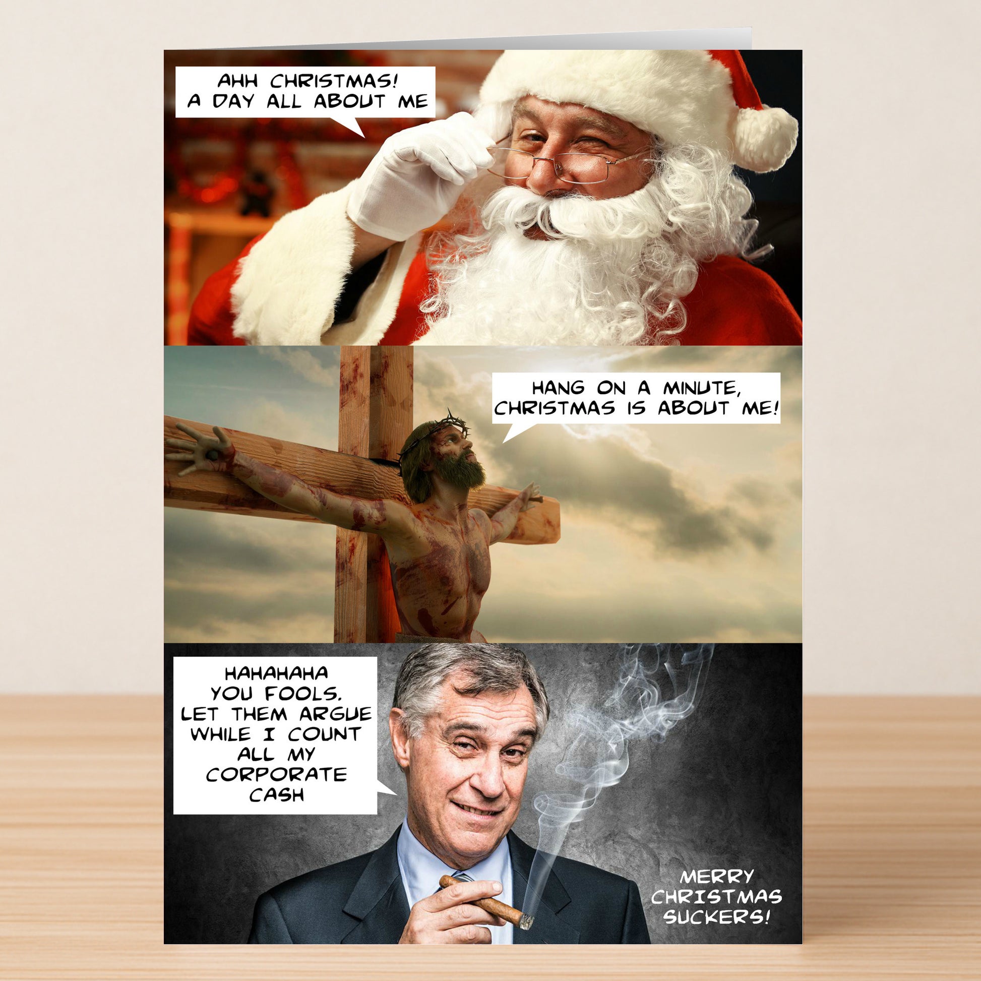 The Suckers Funny Christmas Card by Twisted Gifts features a three-panel comic: Santa and Jesus argue over Christmas, while a businessman counting cash laughs, saying "Merry Christmas, suckers!"—the perfect humorous holiday card.