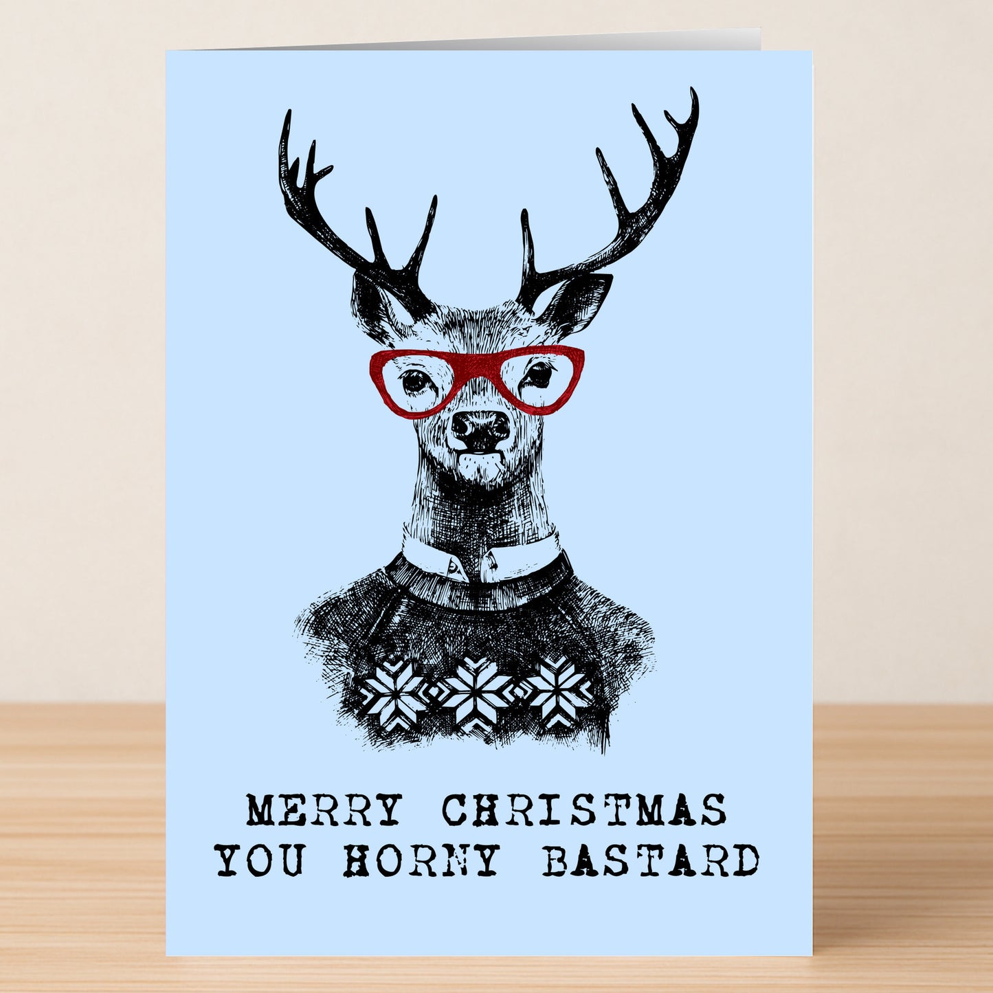 The Horney Bastard Funny Christmas Card by Twisted Gifts features a deer in red glasses and a sweater, sharing the cheeky line “Merry Christmas You Horny Bastard” to add laughter to your holiday season.