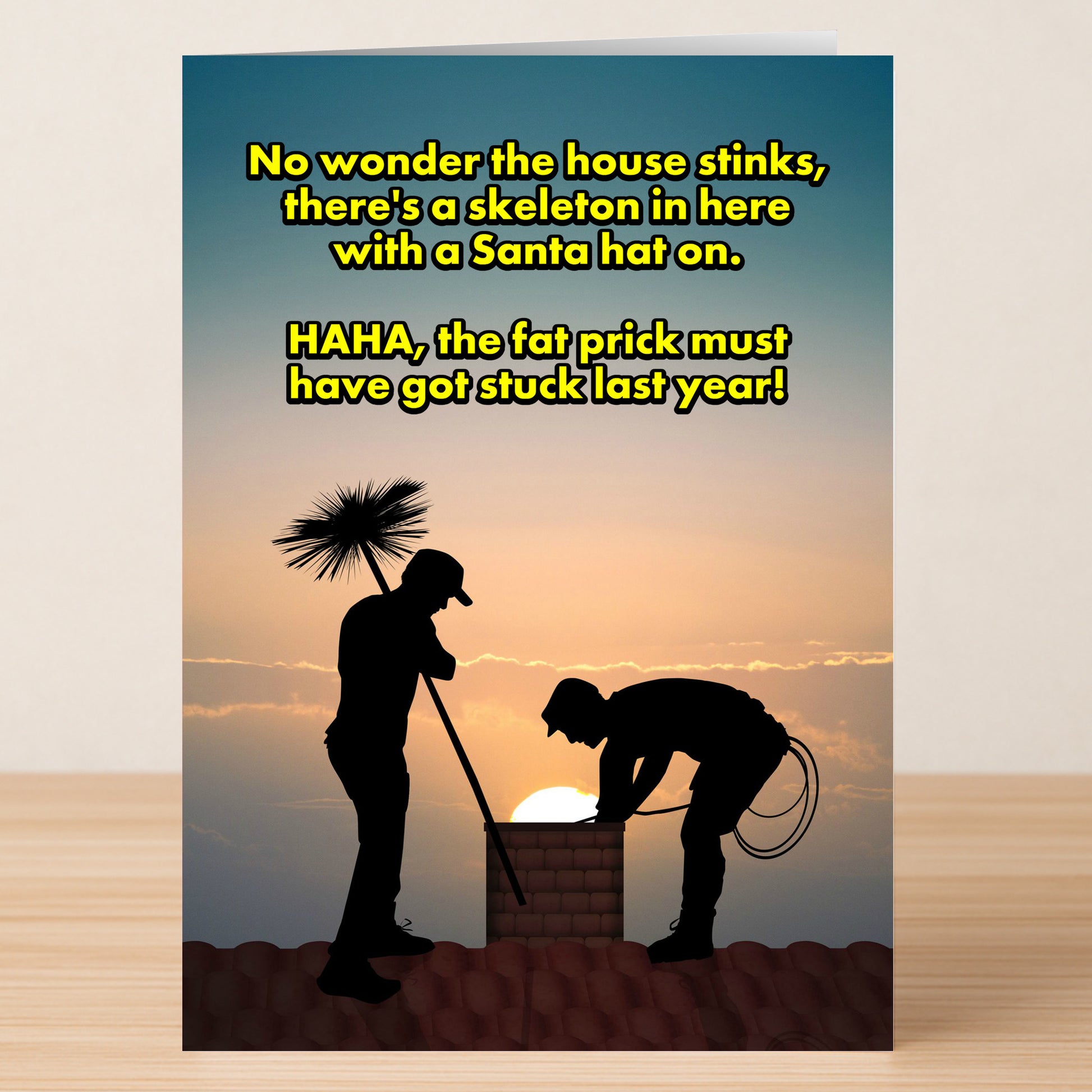 The Got Stuck Funny Christmas Card by Twisted Gifts features two chimney sweeps silhouetted at sunset, with a witty message about finding a skeleton in a Santa hat, perfect for adding festive laughter to the season.