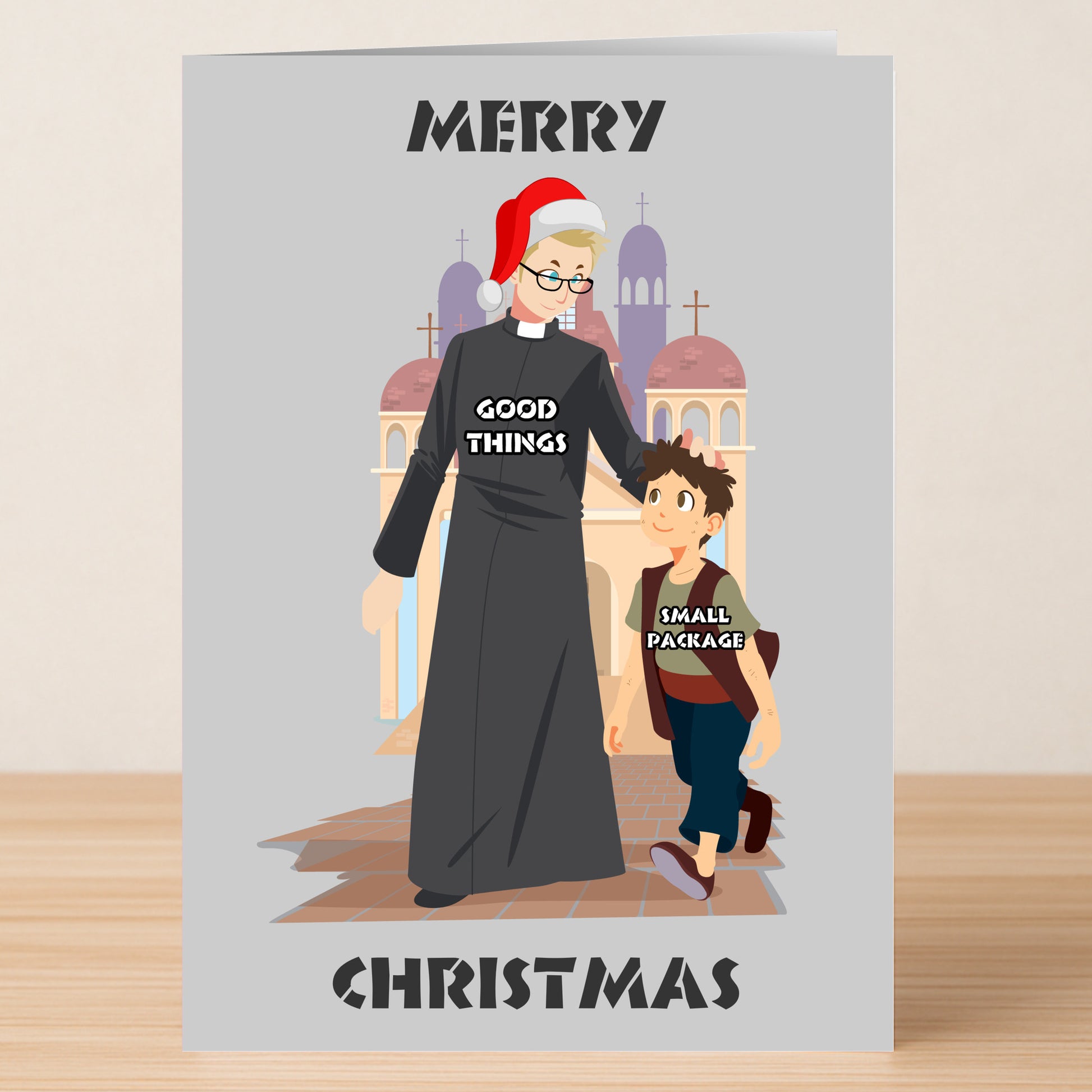 The Good Things Rude Christmas Card by Twisted Gifts features a funny illustration of an older person in a robe and Santa hat labeled "Good Things" with a child called "Small Package" walking past a church.