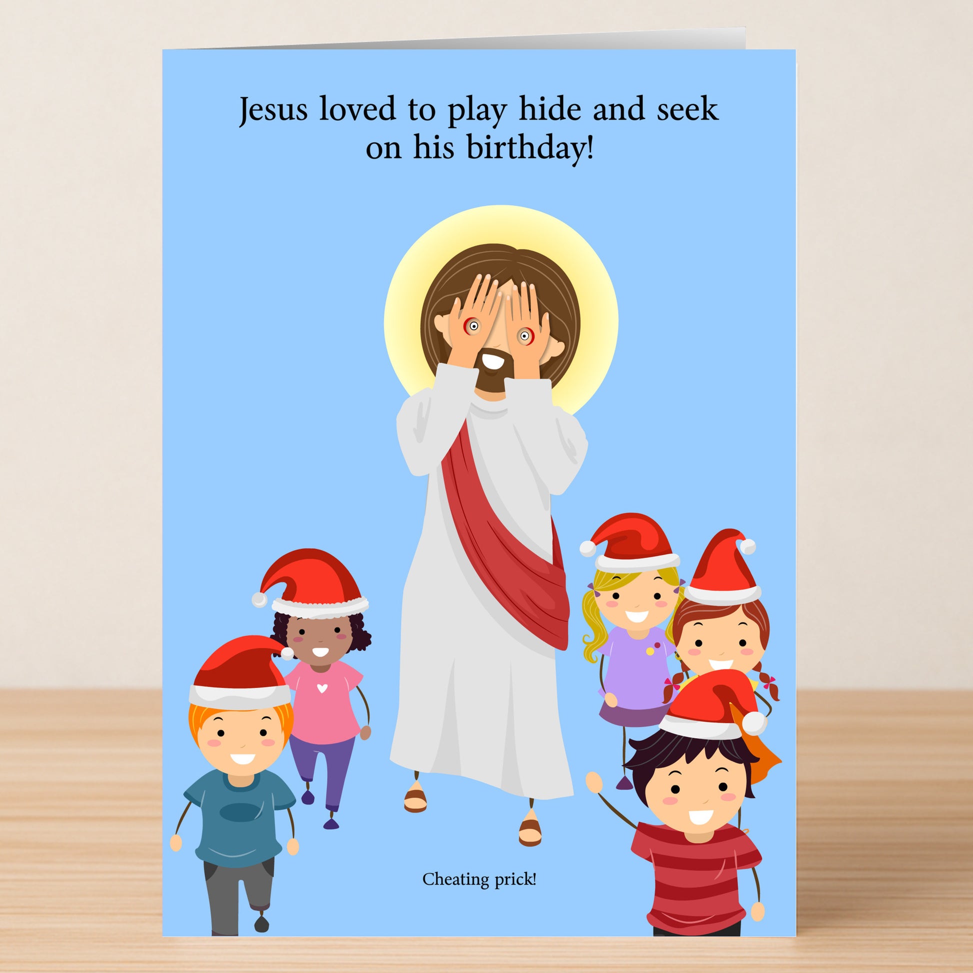 The Hide & Seek Funny Christmas Card by Twisted Gifts features Jesus playing hide and seek with kids in Santa hats, captioned "Jesus loved to play hide and seek on his birthday!"—a playful card for holiday celebrations.