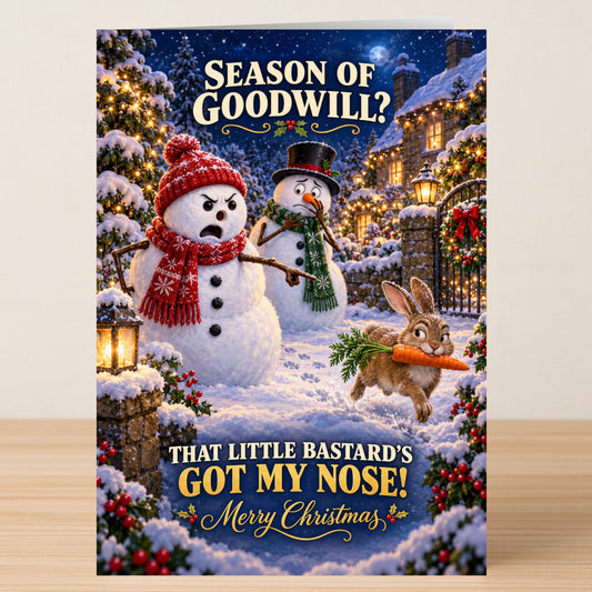 Season Of Good Will - Funny Christmas Card featuring an angry snowman missing his nose, a second snowman, and a rabbit running away with his carrot, captioned: “Season of Goodwill? That little bastard’s got my nose!”.