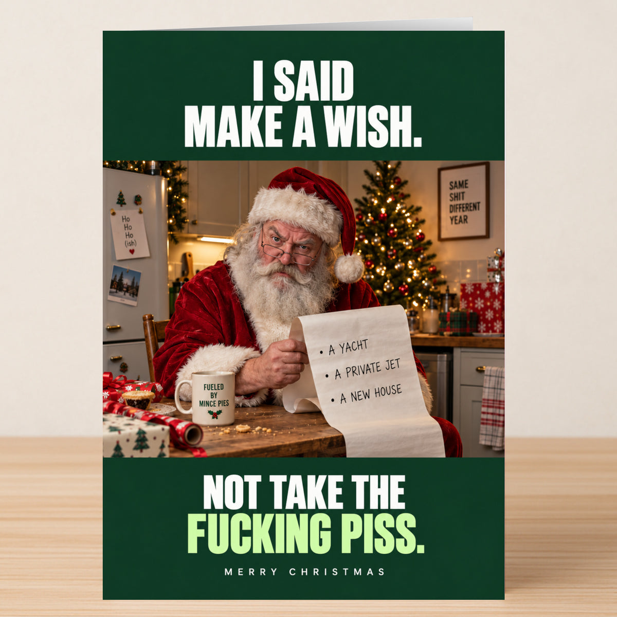A Take The Piss - Funny Christmas Card featuring Santa at a table holding a long wish list for a yacht, jet, and house, with the text: “I said make a wish. Not take the fucking piss.”
