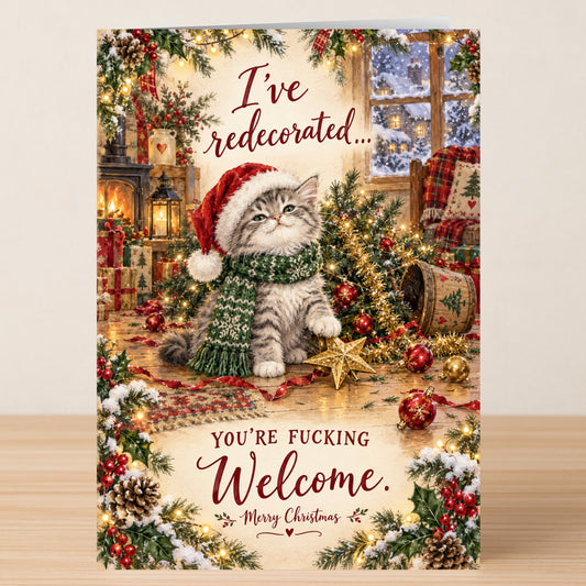 The Redecorated - Funny Christmas Card features a kitten in a Santa hat and scarf sitting by a knocked-over tree, with the text: “I’ve redecorated... You’re fucking welcome. Merry Christmas.”