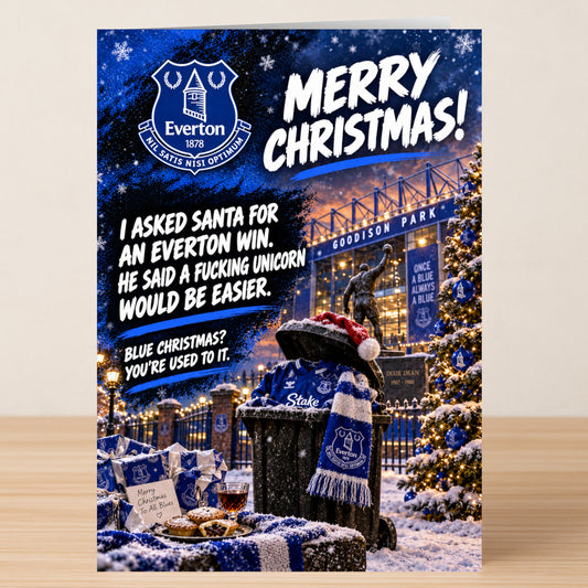 A funny Everton – Funny Christmas Card featuring an Everton jersey in a bin next to a decorated tree with text reading: “Merry Christmas! I asked Santa for an Everton win. He said a fucking unicorn would be easier.”