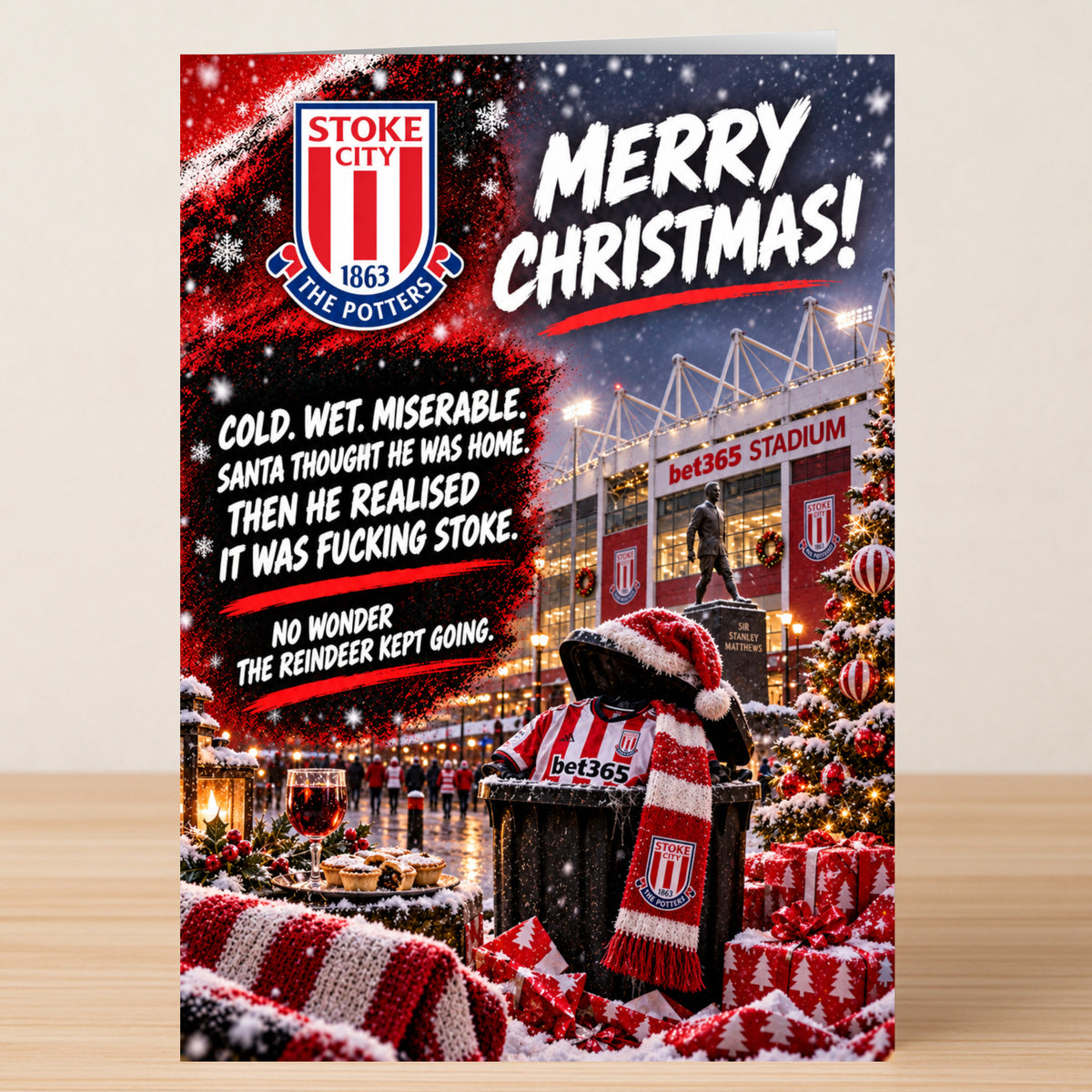 Stoke City – Funny Christmas Card featuring the Stoke City stadium, a trash can filled with a team jersey and scarf, and humorous text about the cold weather.