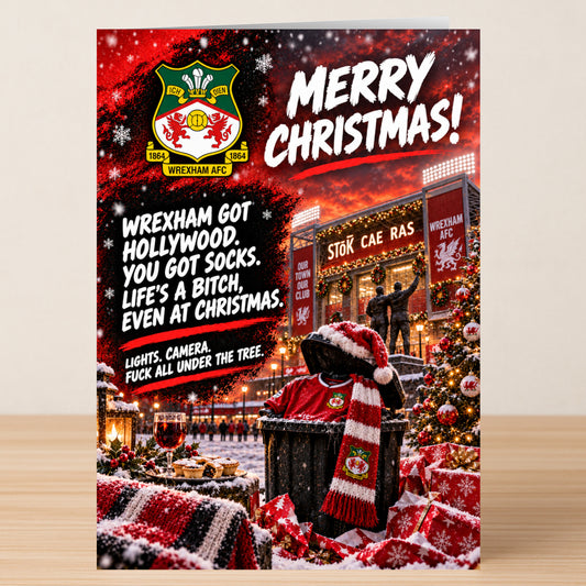 Wrexham AFC – Funny Christmas Card featuring the team logo, a stadium at sunset, festive decorations, and the text: “Merry Christmas! Wrexham got Hollywood. You got socks. Life’s a bitch.”