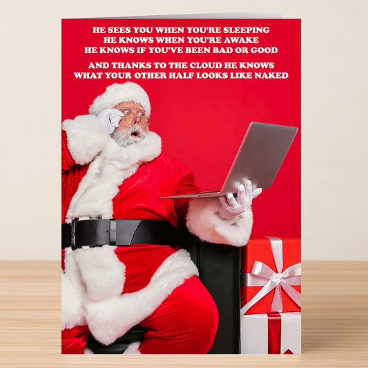 Santa Claus in red, shocked as he holds a laptop next to a big wrapped gift—this hilarious scene from Twisted Gifts' The Cloud Rude Christmas Card is perfect for sharing cheeky holiday vibes and cloud storage jokes.