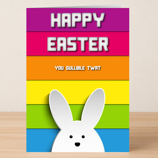 Twisted Gifts’ Gullible Insulting Easter Card features a vibrant rainbow background, cartoon bunny ears, and the text "HAPPY EASTER You gullible twat"—ideal for those who love witty insults and cheeky humor.