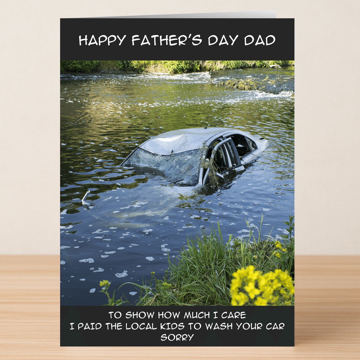 The Sorry Funny Father's Day Card by Twisted Gifts shows a car in a river with the message: "Happy Father’s Day Dad" and "To show how much I care I paid the local kids to wash your car. Sorry." Ideal for dad joke lovers!.