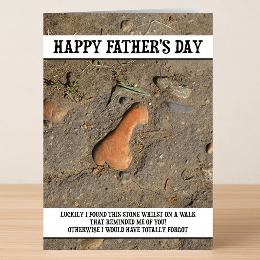 The Found This Stone Rude Father's Day Card by Twisted Gifts features a photo of a stone shaped like a penis on dirt with "HAPPY FATHER'S DAY"—a hilarious card for dads who love to laugh!.