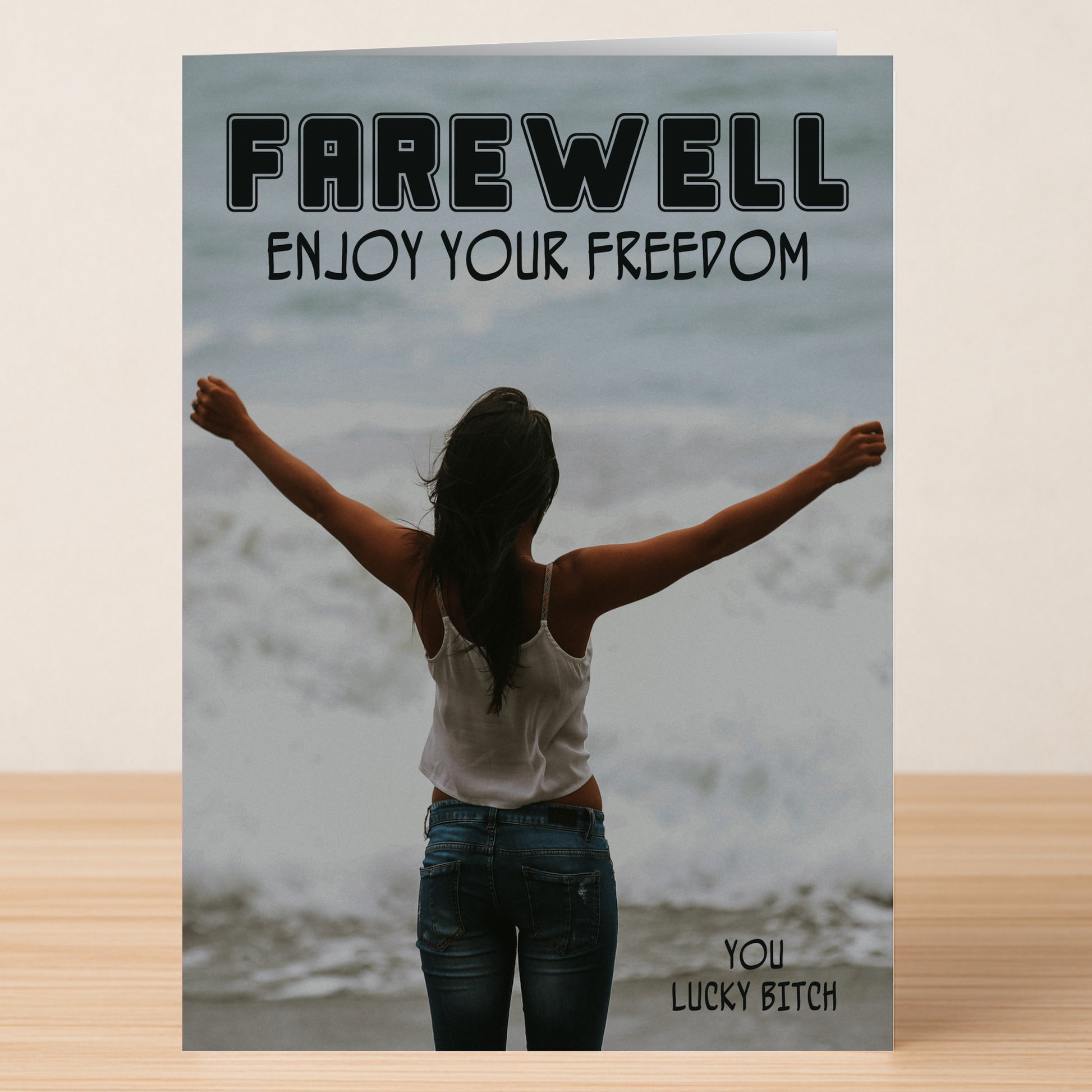 The Lucky Bitch Funny Farewell Card by Twisted Gifts features a woman with arms raised facing the ocean, with "FAREWELL ENJOY YOUR FREEDOM" at the top and "YOU LUCKY BITCH" at the bottom—a perfect pick for lighthearted goodbyes.