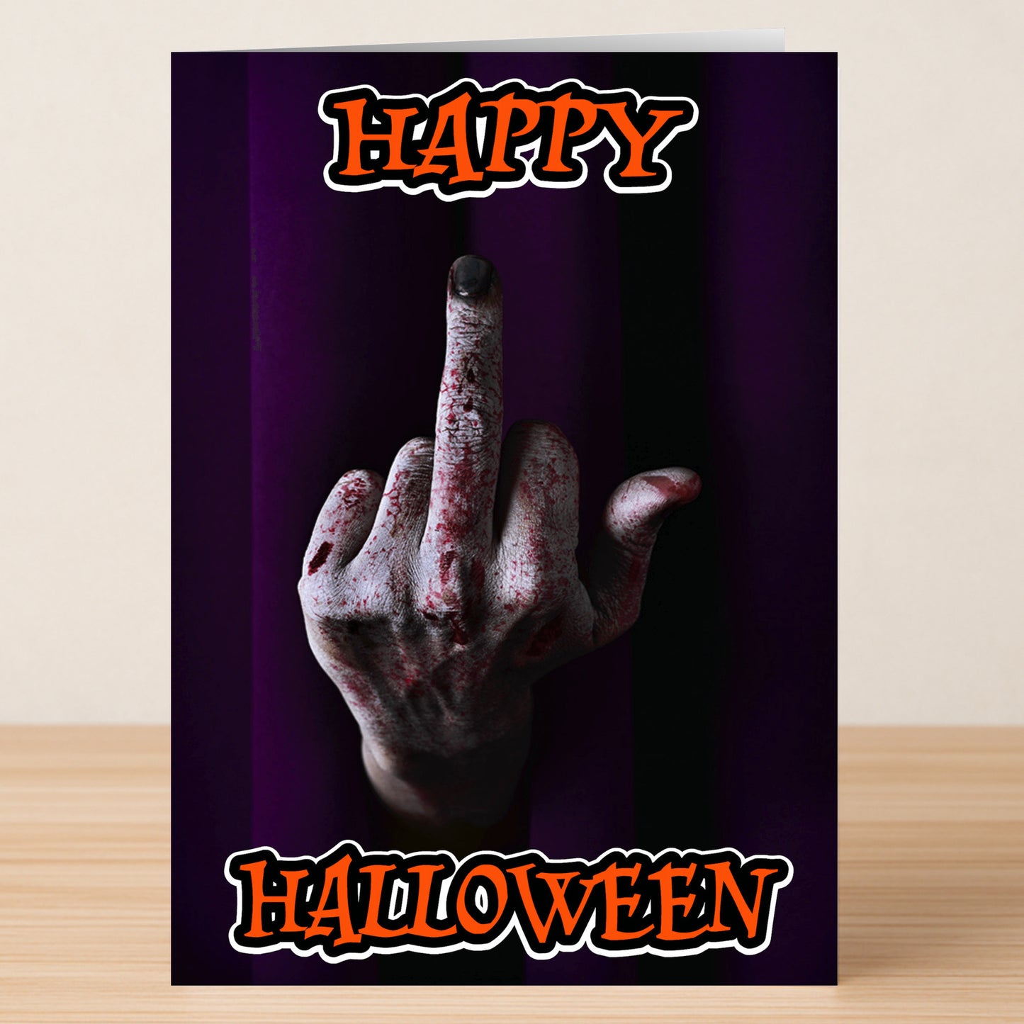 The Happy Halloween Funny Halloween Card by Twisted Gifts features a bloodied hand flipping the middle finger against a dark background with bold orange "Happy Halloween" text—perfect for anyone with a wicked sense of humor.