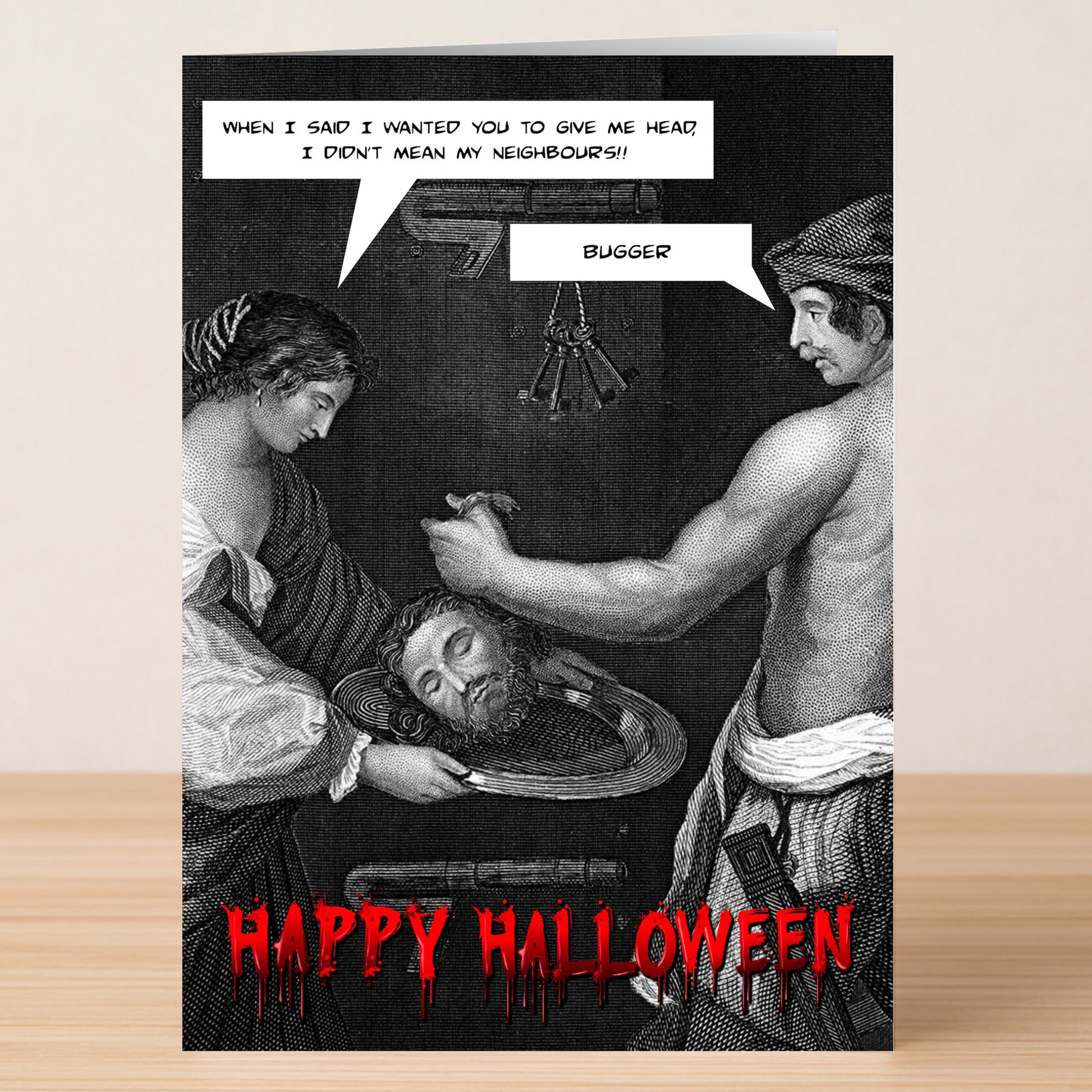 The Give Me Head Rude Halloween Card by Twisted Gifts features engraving-style art of a man presenting a severed head to a woman, with speech bubbles and "Happy Halloween"—a hilariously spooky card for irreverent greetings.