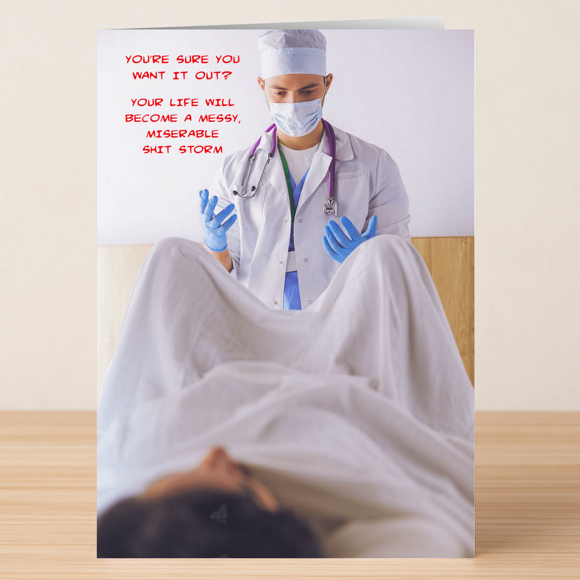 The Are You Sure Funny Mother’s Day Card by Twisted Gifts shows a doctor in gloves and mask between a patient’s legs with bold red text: “YOU’RE SURE YOU WANT IT OUT? YOUR LIFE WILL BECOME A MESSY, MISERABLE SHIT STORM.” Hilarious!.