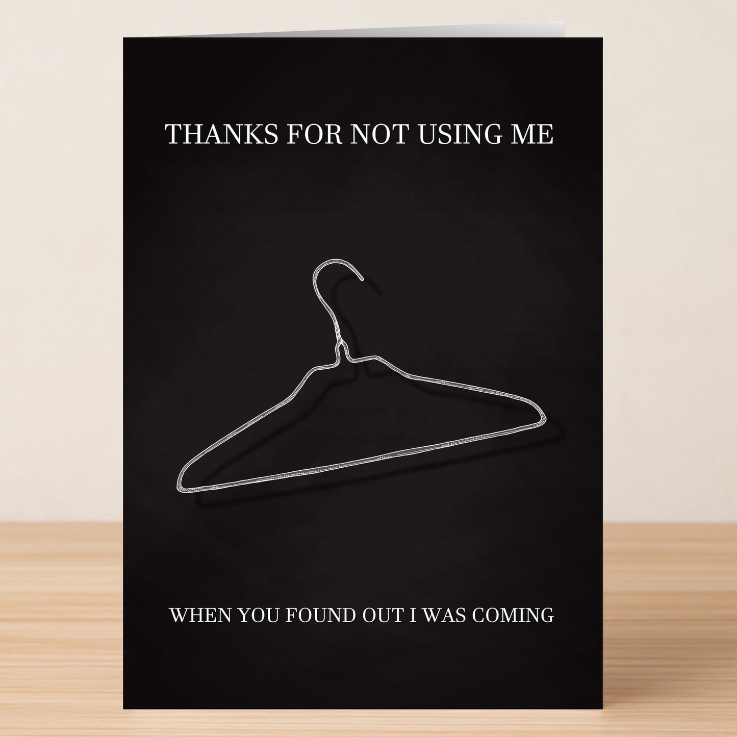 The Coat Hanger Insulting Mother's Day Card by Twisted Gifts features a wire hanger design with the message, "THANKS FOR NOT USING ME," above and, "WHEN YOU FOUND OUT I WAS COMING," below—a bold, blunt card for Mother's Day.