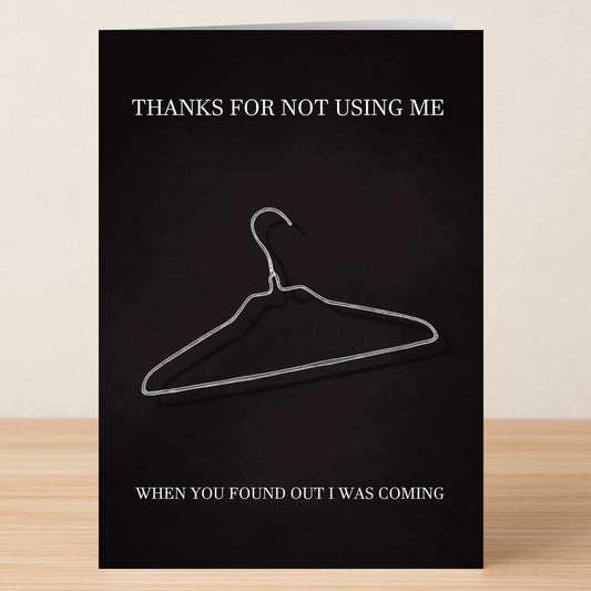 The Coat Hanger Insulting Mother's Day Card by Twisted Gifts features a wire hanger design with the message, "THANKS FOR NOT USING ME," above and, "WHEN YOU FOUND OUT I WAS COMING," below—a bold, blunt card for Mother's Day.
