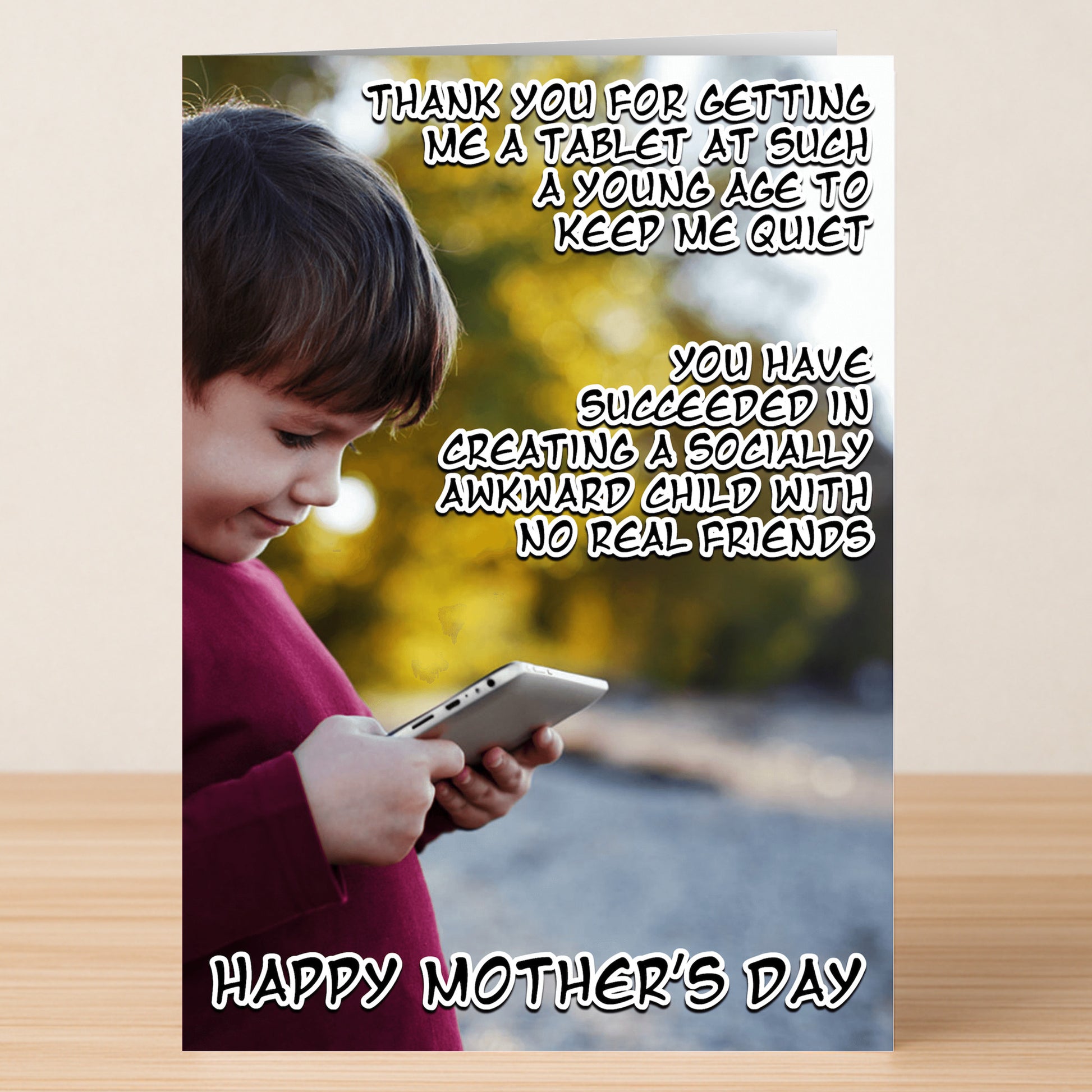 A young child gazes at a tablet outside. The "Socially Awkward Funny Mother's Day Card" by Twisted Gifts features humorous text thanking mom for raising someone awkward and "Happy Mother's Day" below—a perfect card for laughs.