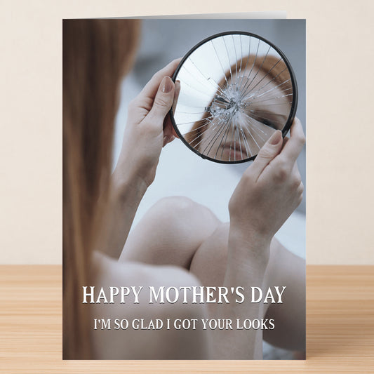 The "Got Your Looks Funny Mother's Day Card" by Twisted Gifts features a woman holding a broken mirror, her face reflected, with the message: "Happy Mother's Day. I'm so glad I got your looks." A card sure to make Mom smile.