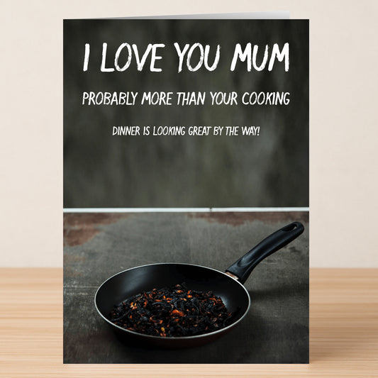 The Great Cooking Insulting Mother's Day Card by Twisted Gifts features a funny message—“I love you mum probably more than your cooking. Dinner is looking great by the way!”—with burnt food art, ideal for mums who love a laugh!.