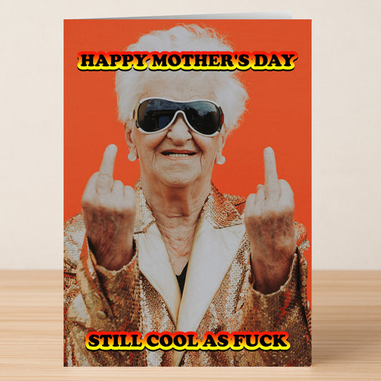 The Cool As Fuck Funny Mother's Day Card by Twisted Gifts shows an elderly woman in sunglasses and a gold jacket raising both middle fingers with the text, "Happy Mother’s Day. Still cool as fuck." Perfect for moms who never lost their edge.