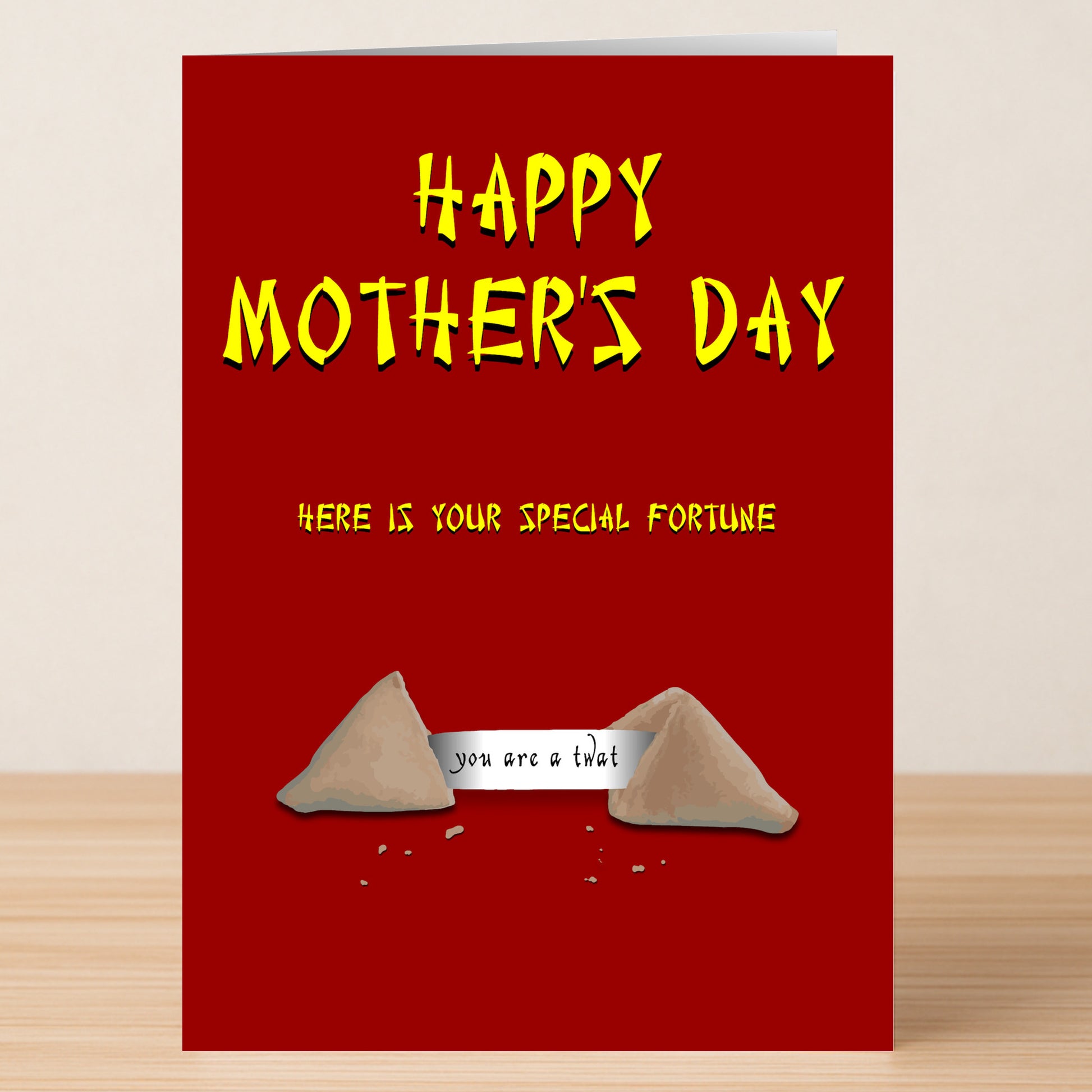 The Fortune Cookie Insulting Mother's Day Card by Twisted Gifts features a red design with yellow text and a fortune cookie illustration that reads, "you are a that." Ideal for moms who enjoy offbeat humor and playful insults.