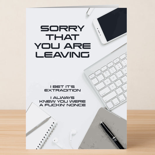 The Twisted Gifts Nonce Insulting Sorry Card sits on a desk among office items, featuring the message: "SORRY THAT YOU ARE LEAVING. I BET IT'S EXTRADITION. I ALWAYS KNEW YOU WERE A FUCKIN' NONCE.
