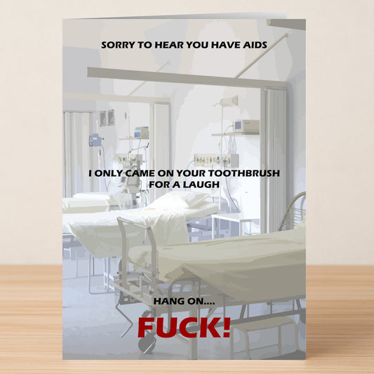 A hospital room with empty beds and medical gear. Overlaid is harsh, crude text from Twisted Gifts' "Just A Laugh Rude Sorry Card," making it reminiscent of a rude sorry card rather than a typical greeting card.