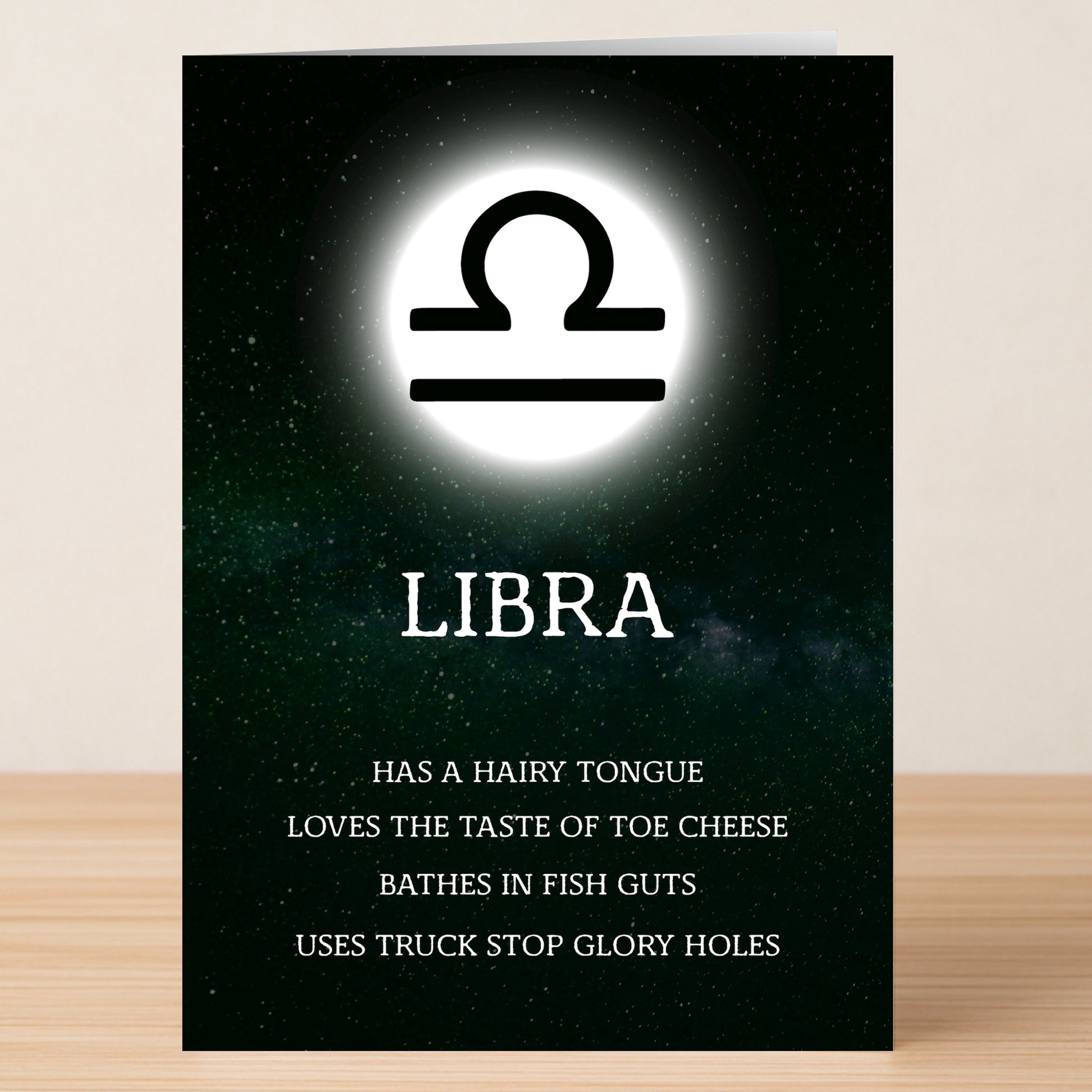 The Libra Rude Star Sign Card by Twisted Gifts showcases the zodiac symbol above "LIBRA," listing bold, cheeky traits below—a witty, irreverent gift with a starry background.