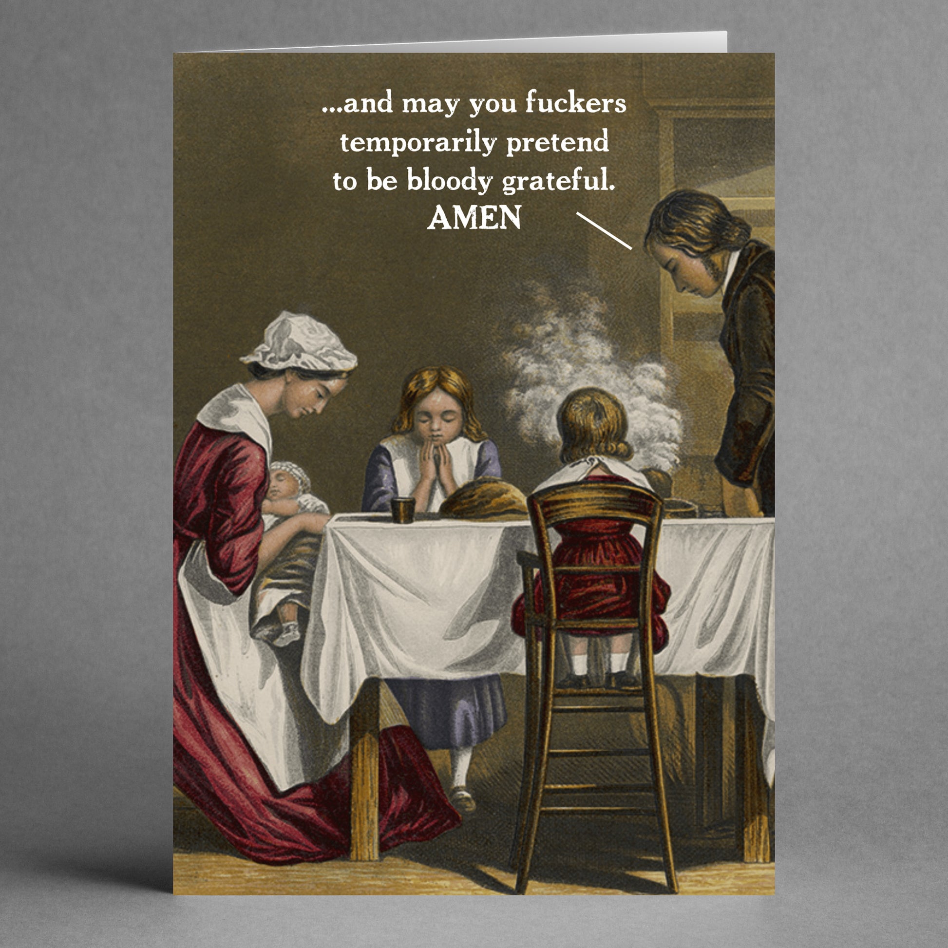 A vintage-style image depicts a family gathered at a Thanksgiving dinner table with a speech bubble saying, "...and may you temporarily pretend to be grateful. Amen." This card, named the "Amen Rude Thanksgiving Card" by Twisted Gifts, is perfect for those who enjoy humorous and irreverent Thanksgiving greetings.