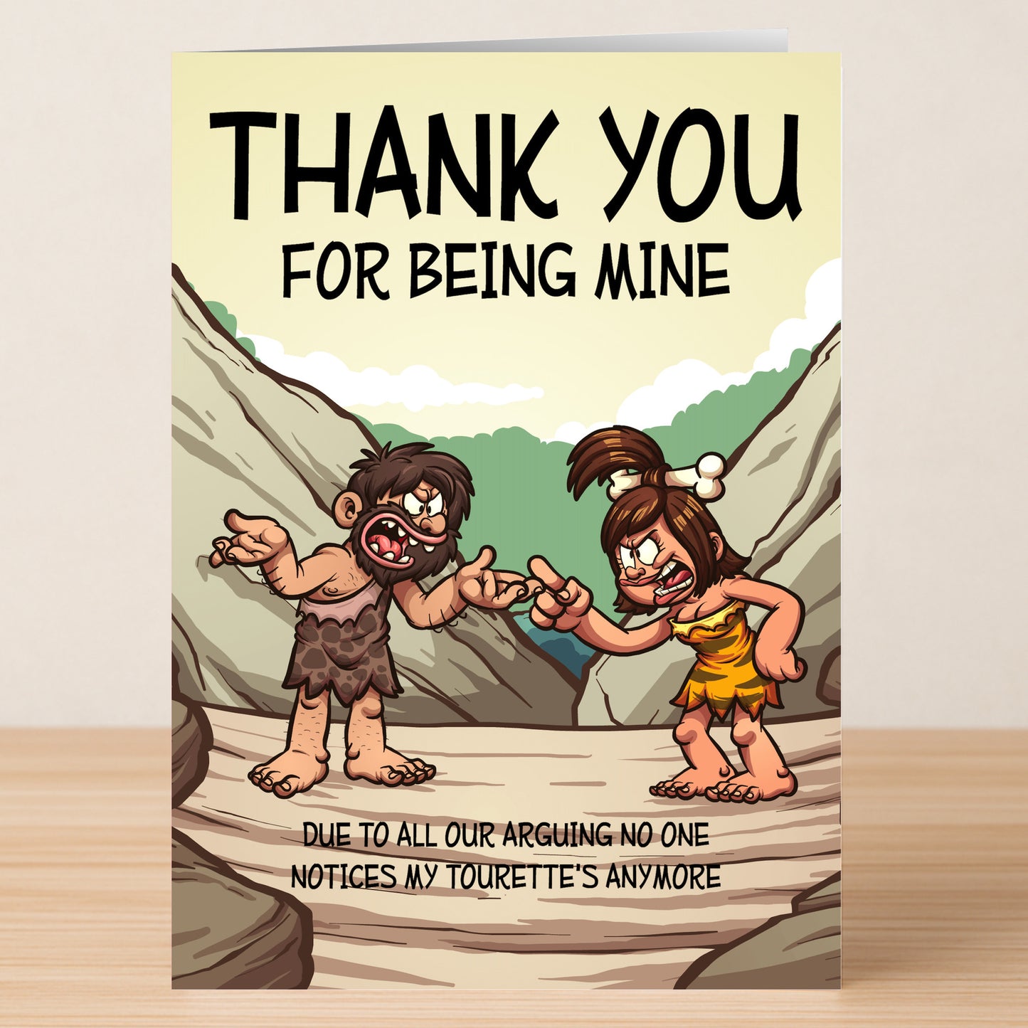 Twisted Gifts’ Tourettes Funny Thank You Card features cartoon cave people arguing with the caption: “THANK YOU FOR BEING MINE. Due to all our arguing, no one notices my Tourette’s anymore.”.