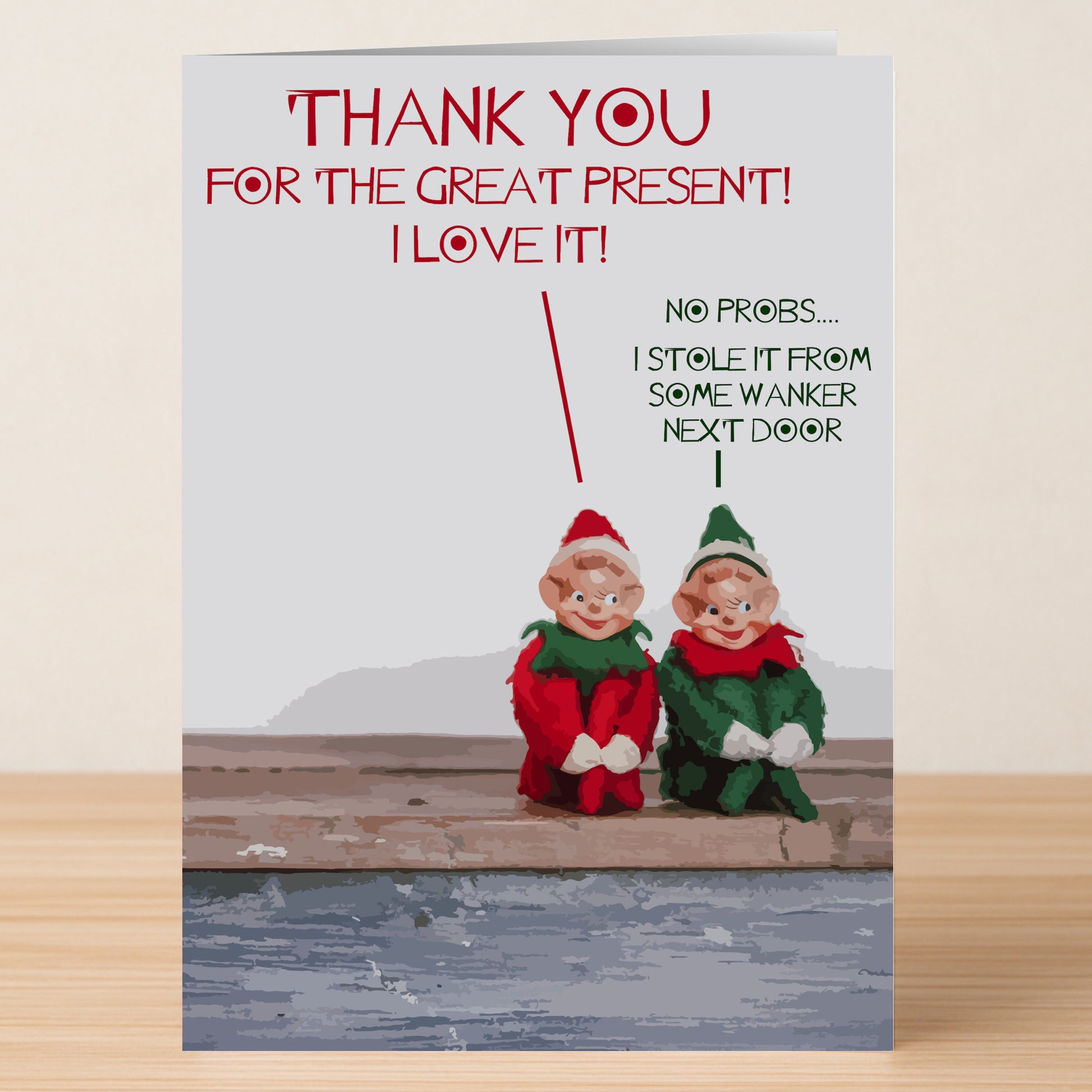 Two elf dolls sit on wood. One says, "THANK YOU FOR THE GREAT PRESENT! I LOVE IT!" The other replies, "No probs... I stole it from some wanker next door." Gnomes Funny Thank You Card by Twisted Gifts—gratitude with a twist!.