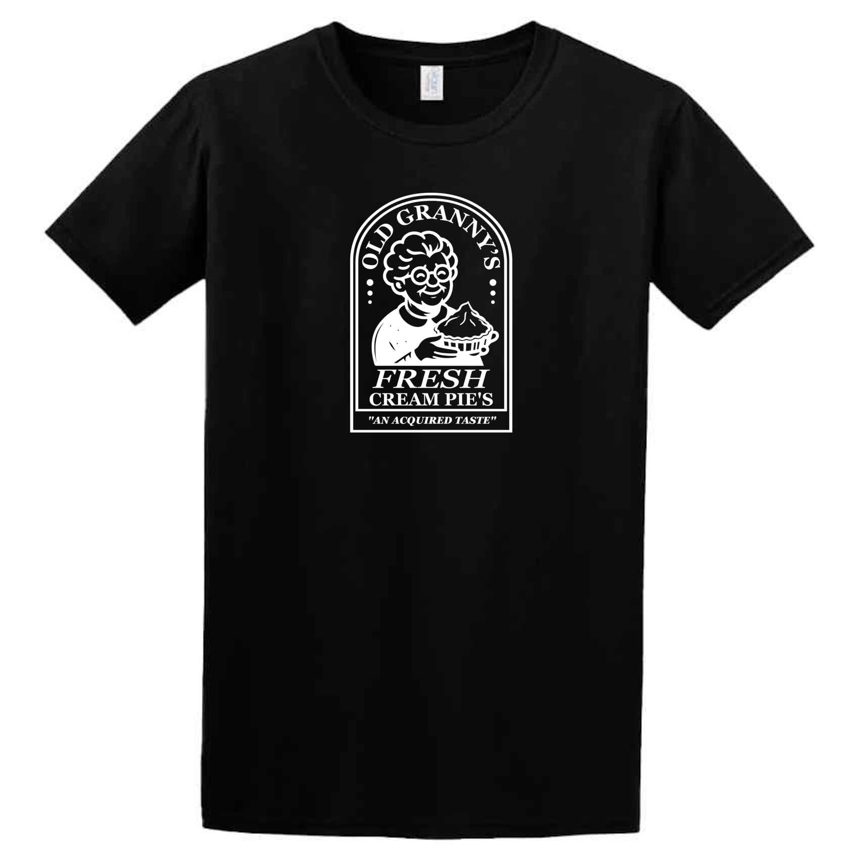 Twisted Gifts' Cream Pies T-Shirt features a black design with a white graphic of an elderly woman holding a pie and the text "Old Granny's Fresh Cream Pies 'An acquired taste'." A fun novelty shirt for quirky style lovers.