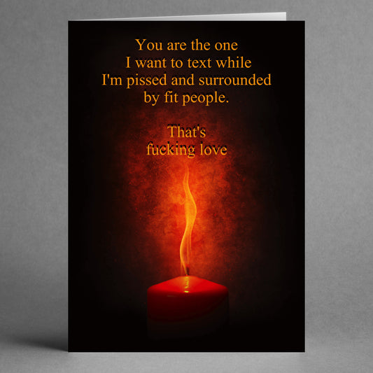 Introducing the "That's Love Insulting Valentine's Card" by Twisted Gifts. This humorous greeting card showcases a red candle and reads: "You are the one I want to text while I'm pissed and surrounded by fit people. That's fucking love." It's ideal for anyone who enjoys edgy humor on Valentine's Day!