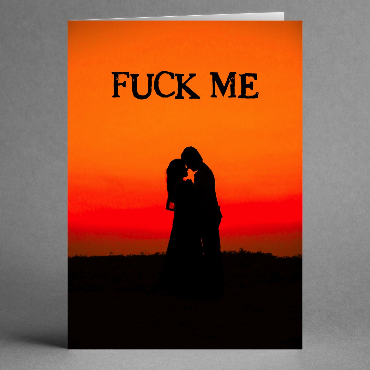 The "Fuck Me Rude Valentine's Card" by Twisted Gifts showcases a couple's silhouette embracing against an orange sunset, with the cheeky phrase "FUCK ME" boldly displayed at the top, bringing a humorous twist to this playfully unconventional greeting.