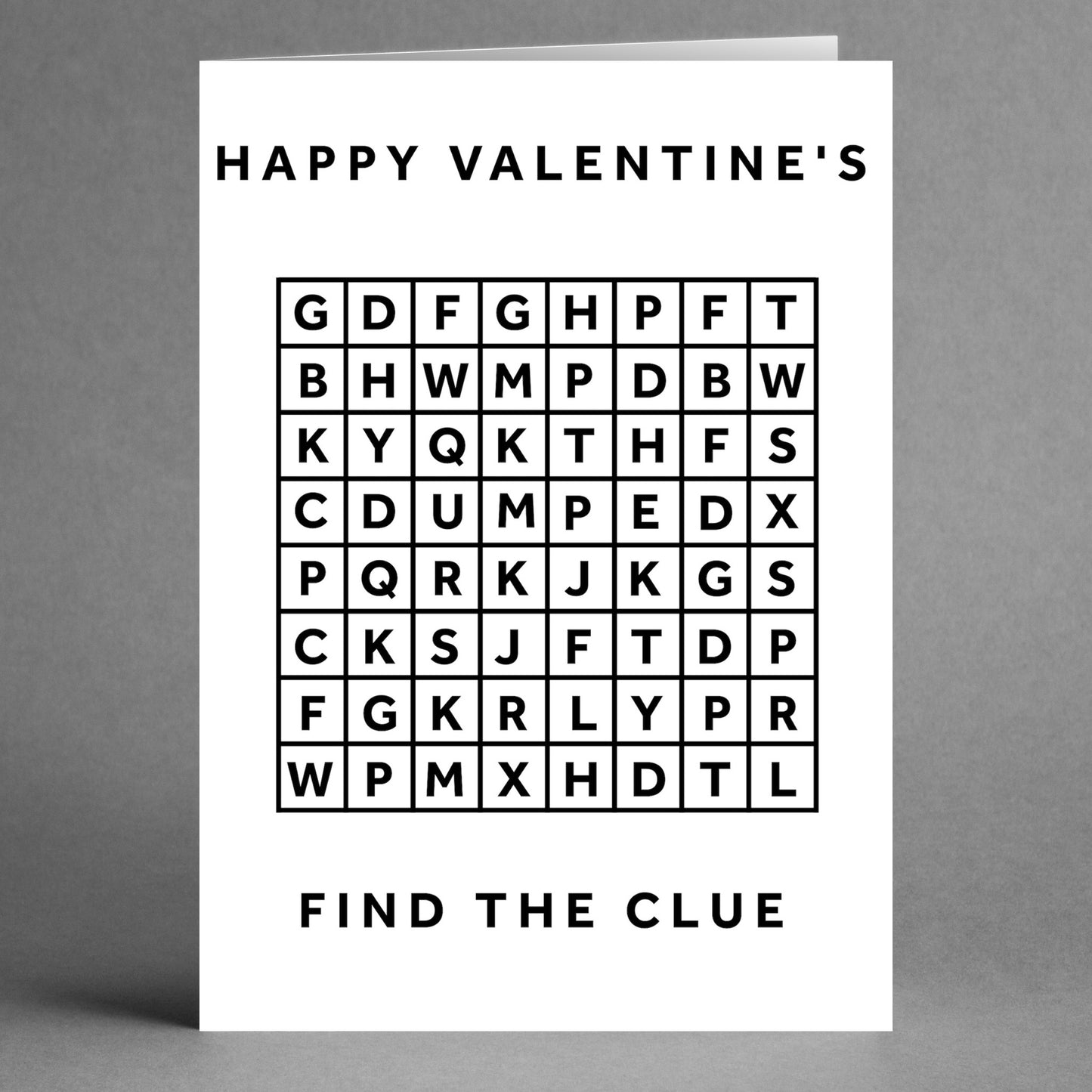 The Word Search Funny Valentine's Card by Twisted Gifts showcases a humorous message, with "Happy Valentine's" at the top and "Find the Clue" at the bottom, all centered around a word search grid filled with random letters.