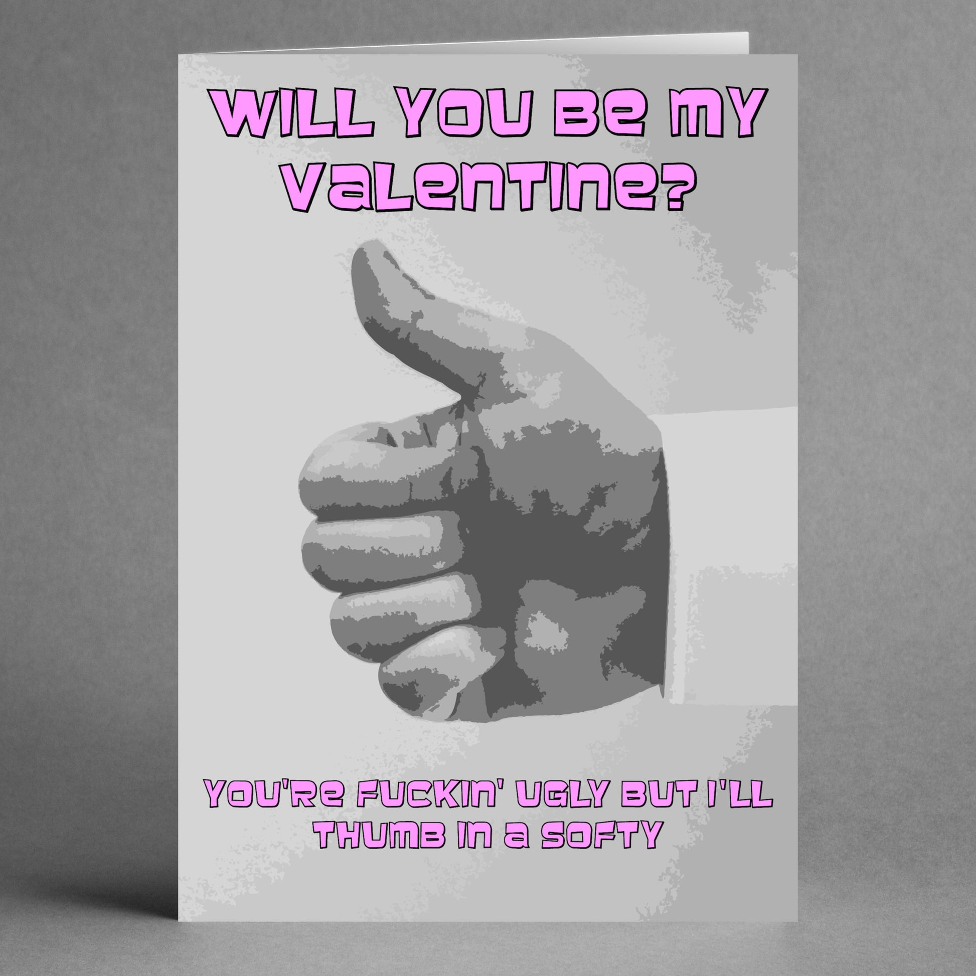 The Thumb In A Softy Twisted Valentine's Card from Twisted Gifts adds a unique twist to traditional romance with its playful thumbs-up image and cheeky pink text: "Will you be my valentine?" and "You're fuckin' ugly but I'll thumb in a softy.