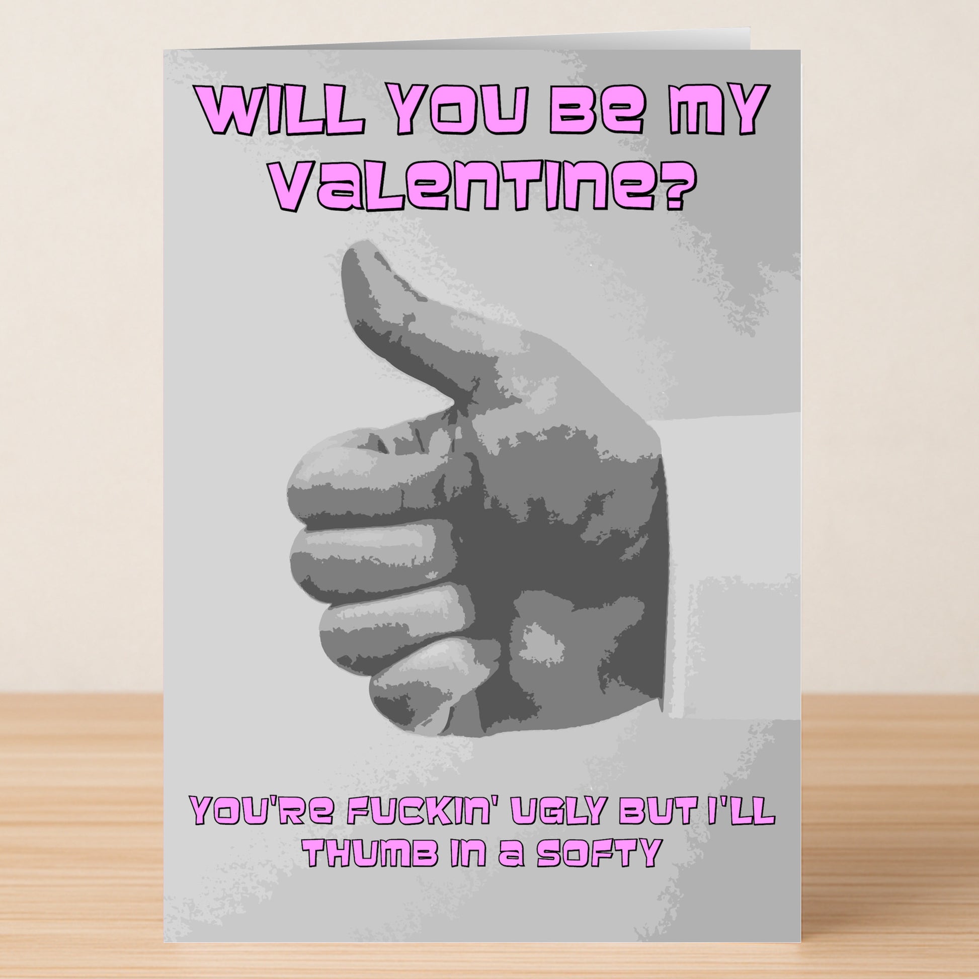 The "Thumb In A Softy Twisted Valentine's Card" by Twisted Gifts features a grayscale thumbs-up and bold pink text: "Will you be my Valentine? You're fuckin' ugly but I'll thumb in a softy." Perfect for those with a twisted sense of humor.