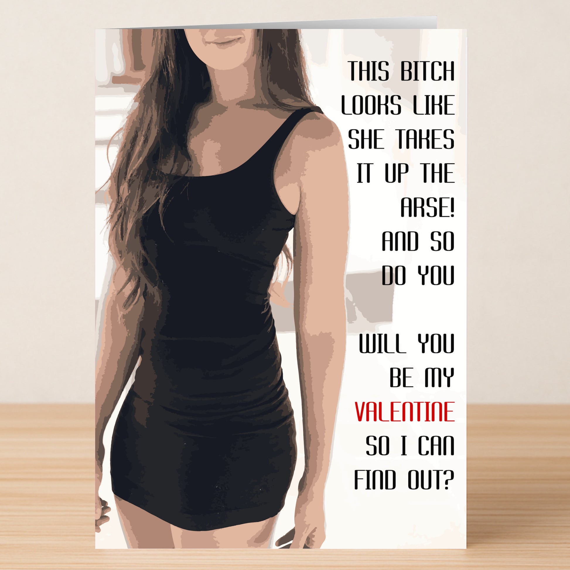 A woman in a black dress stands indoors beside the "This Bitch Twisted Valentine's Card" from Twisted Gifts, known for its playful, humorous, and provocative message.