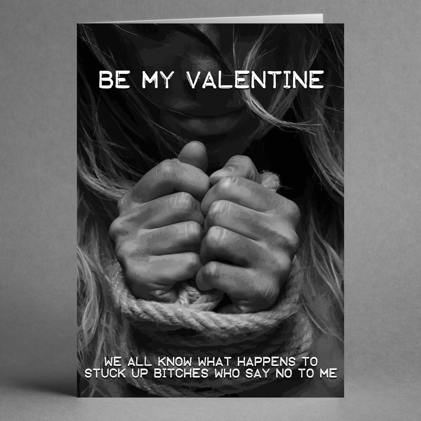 A grayscale image on the "Stuck Up Twisted Valentine's Card" by Twisted Gifts showcases a person's hands tied with rope, accompanied by the words "Be My Valentine" and a playful, unconventional love message.