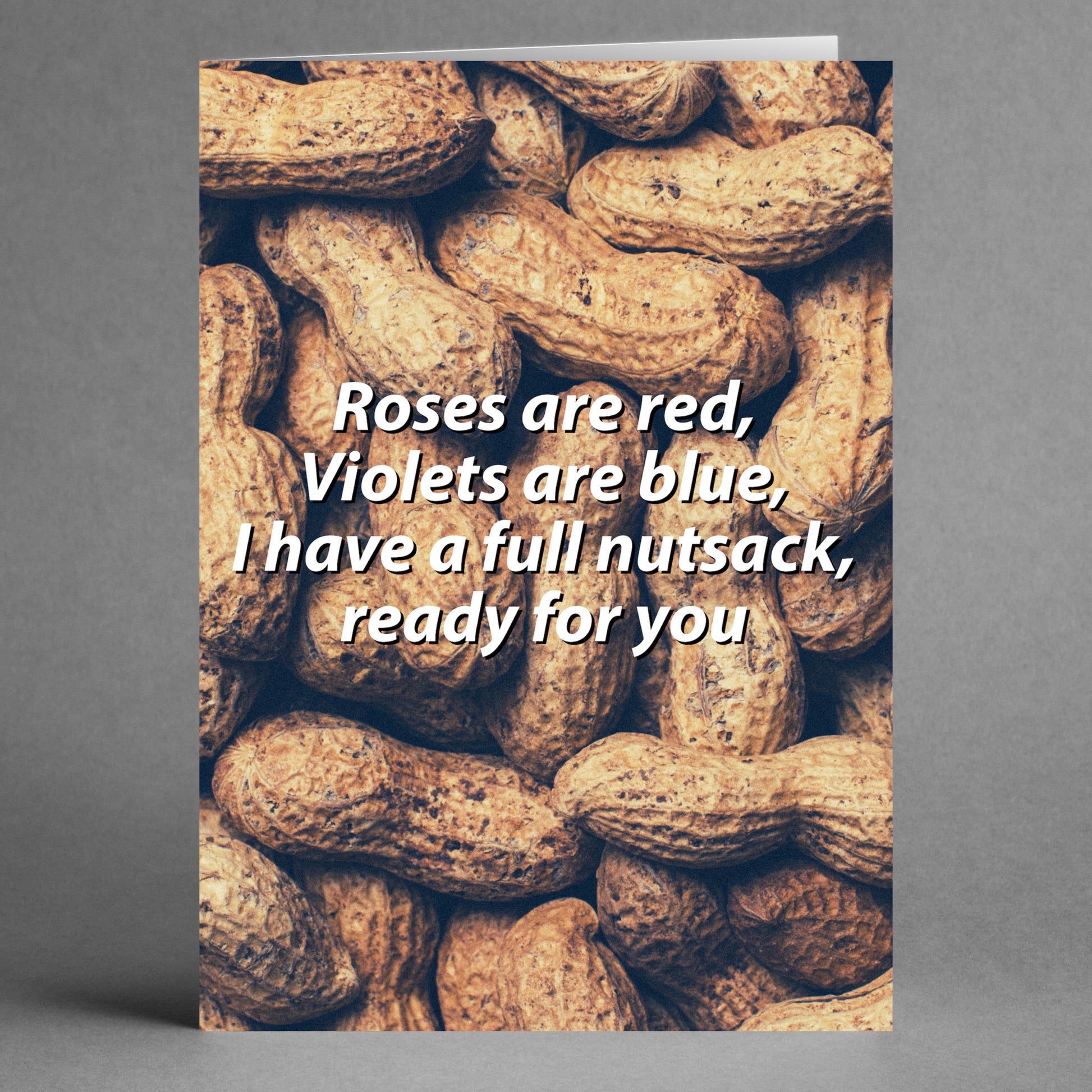 Twisted Gifts' Nut Sack Twisted Valentine's Card showcases a humorous image of a pile of peanuts with the playful message: "Roses are red, Violets are blue, I have a full nutsack, ready for you.