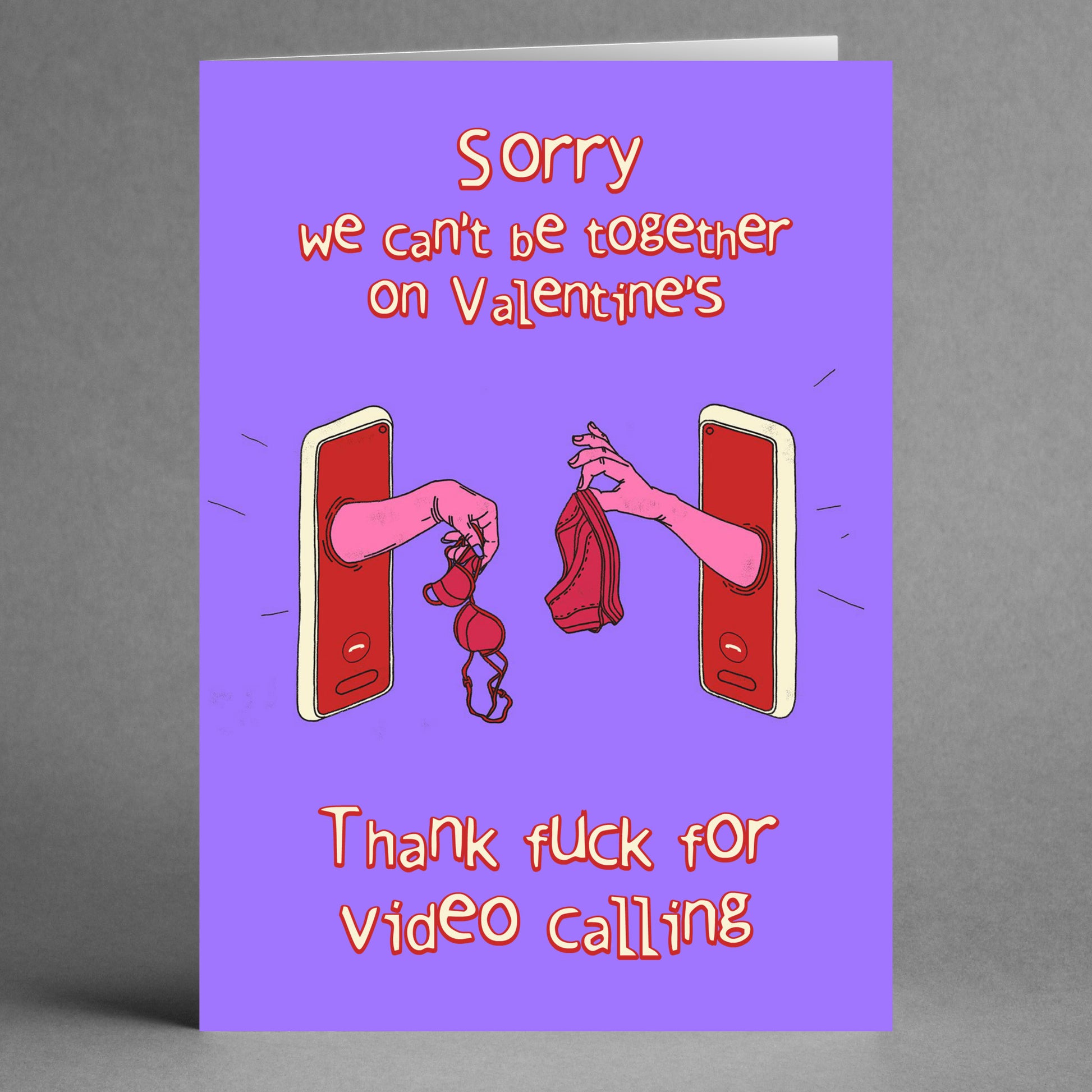 Twisted Gifts' Video Calling Rude Valentine's Card humorously captures the essence of love meeting technology. The cheeky design shows two hands reaching through phone screens, one holding a bra and the other gripping panties, accompanied by the text, "Sorry we can’t be together on Valentine's. Thank fuck for video calling.