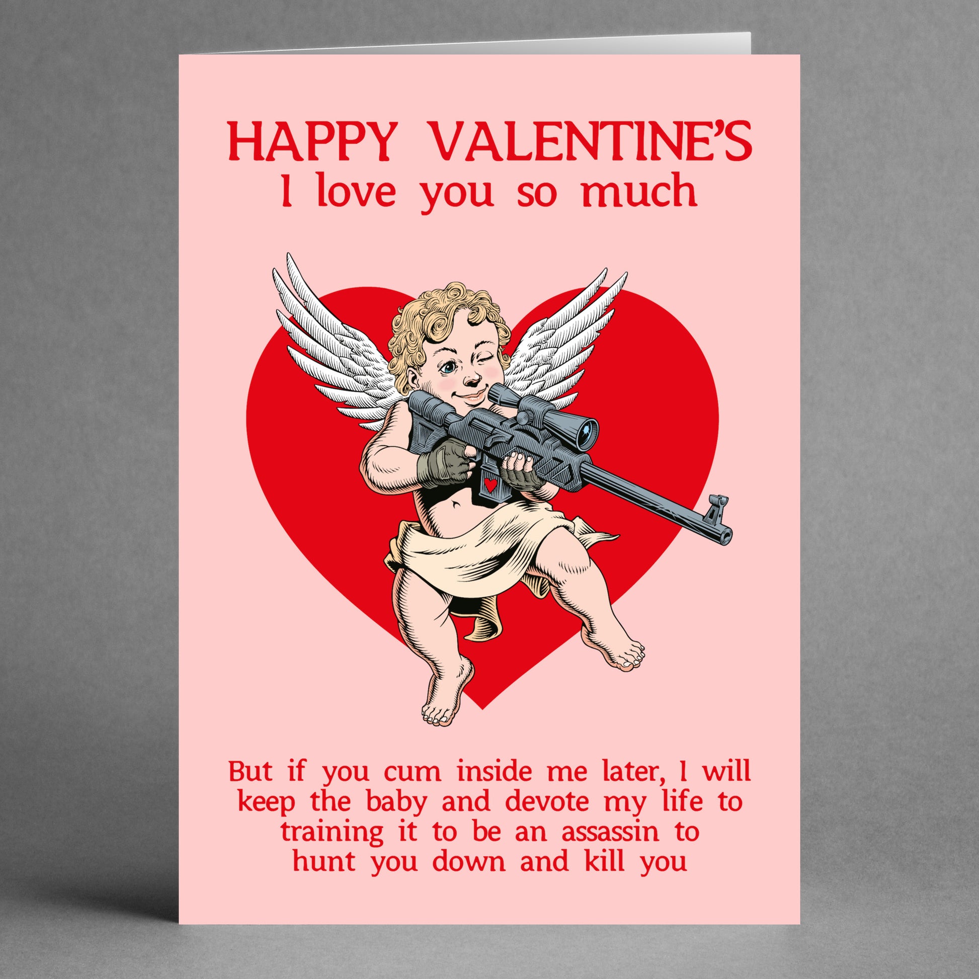 The "Assassin" Funny Valentine's Card by Twisted Gifts showcases a cheeky twist on love and revenge with its depiction of an angel-turned-assassin humorously wielding a rifle over a red heart, making it the perfect choice for those who appreciate humorous greetings.