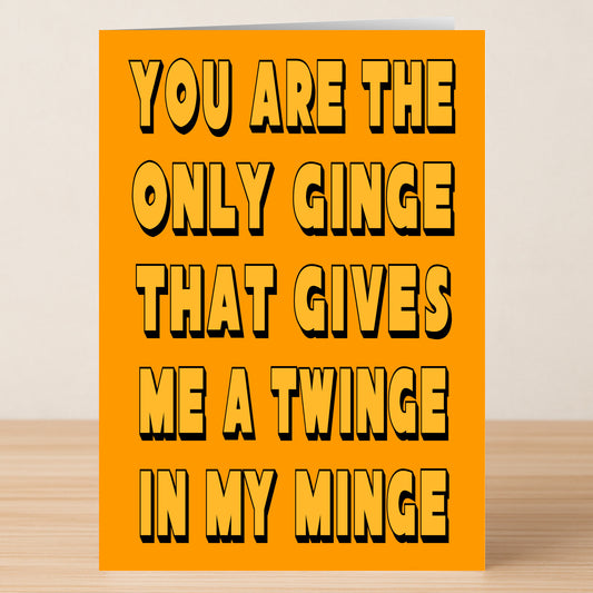 The Twinge Funny Valentine's Card by Twisted Gifts features bold black text on orange: "You are the only ginge that gives me a twinge in my minge." A perfect limited edition card for someone special, shown on a wooden surface.