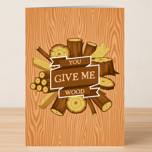 The Wood Funny Greeting Card by Twisted Gifts features a wood grain background, cut logs, and branches, with a central banner that says "You Give Me Wood"—making it a playful and lighthearted valentine's card.