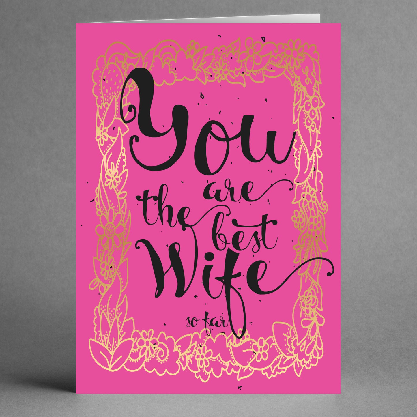 The So Far Funny Greeting Card by Twisted Gifts features a witty design with a pink background, black text that reads "You are the best wife so far," and gold floral decorations, making it a humorous addition to your Valentine’s Day sentiments.